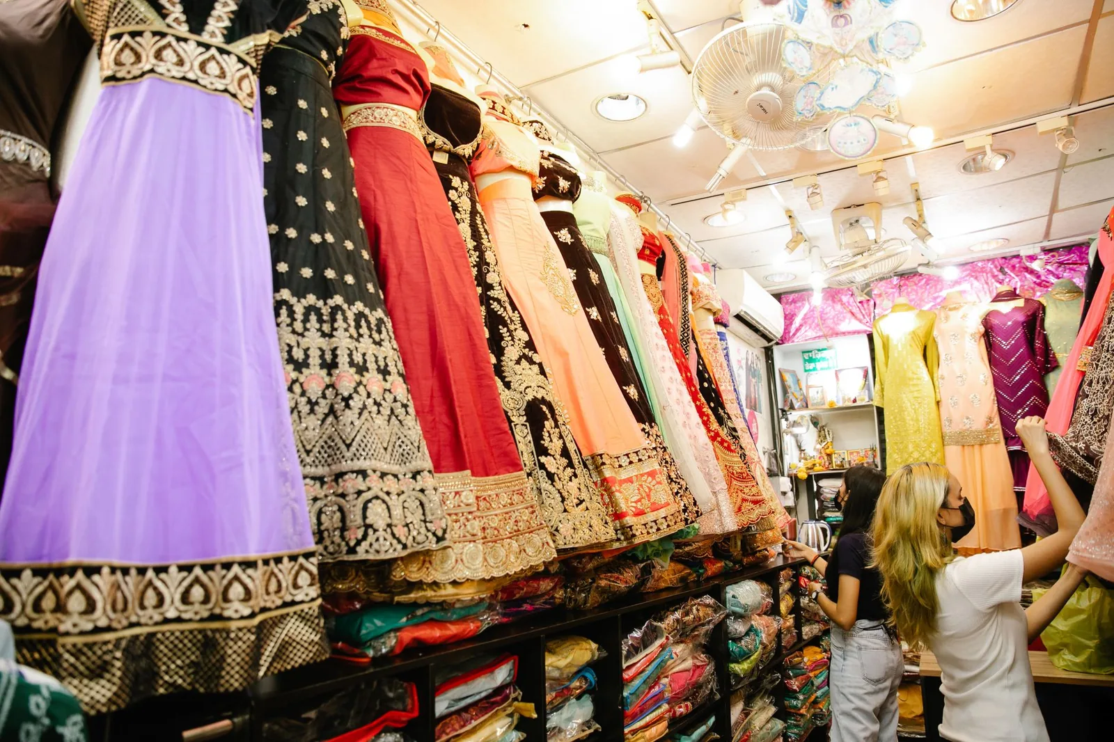 Rows of colourful Indian ethnic wear and lehengas on display in a boutique